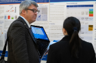 Gil I. Wolfe, MD, professor and chair of neurology, listens to a medical student explain her research project.